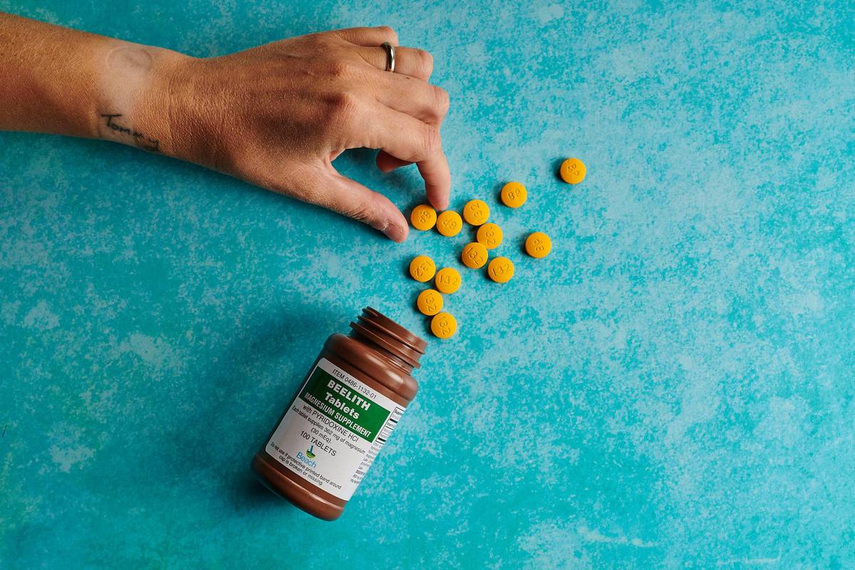 holding a yellow supplement pill